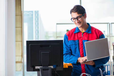 Computer repairman working on repairing computer in IT workshopの写真素材