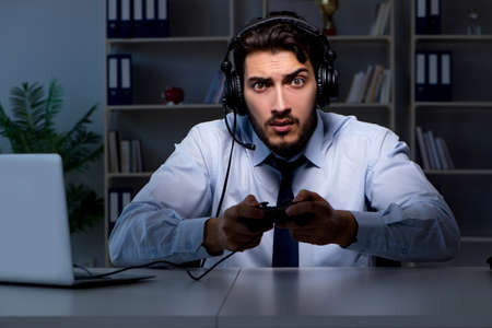 Businessman gamer staying late to play gamesの写真素材