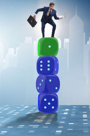 Businessman balancing on top of dice stack in uncertainty concepの写真素材