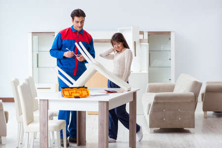 Contractor repairman assembling furniture under woman supervisionの写真素材