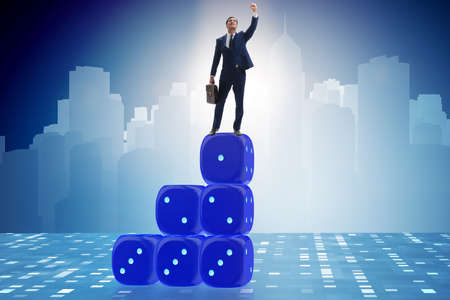 Businessman balancing on top of dice stack in uncertainty concepの写真素材