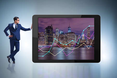 Businessman standing next to tablet computer in business conceptの写真素材