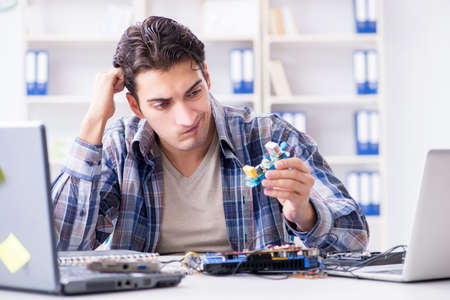 Professional repairman repairing computer in workshop