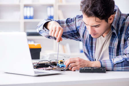 Professional repairman repairing computer in workshop