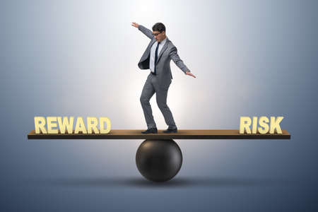 Businessman balancing between reward and risk business conceptの写真素材