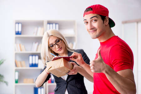 Woman businesswoman receiving mail parcel from courierの写真素材