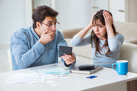 Young couple looking at family finance papersの写真素材