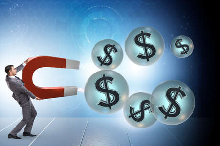 Businessman catching dollars on horseshoe magnetの写真素材