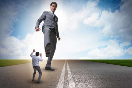 Bad angry boss kicking employee in business conceptの写真素材