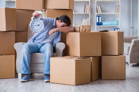 Young man moving in to new house with boxesの写真素材