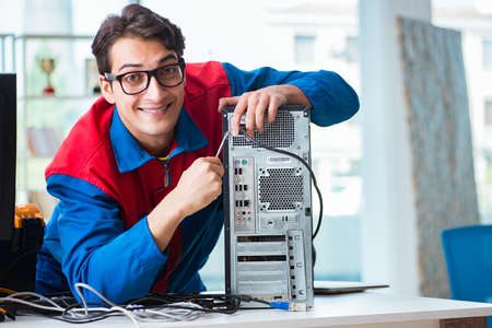 Computer repairman working on repairing computer in IT workshopの写真素材