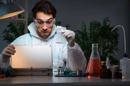 Forensic investigator working in lab looking for evidenceの写真素材