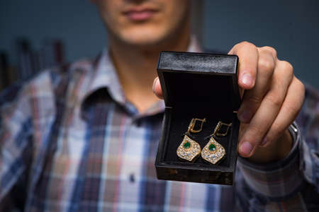 Young male jeweller working at night in his workshopの写真素材