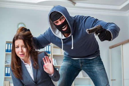 Criminal taking businesswoman as hostage in officeの写真素材