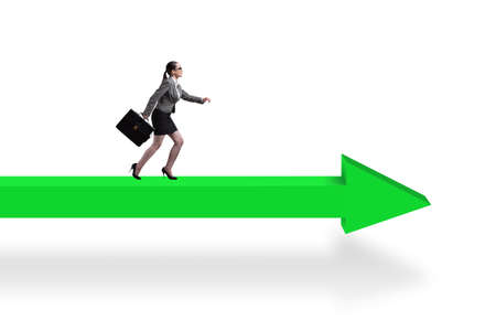 Businesswoman walking on arrow signの写真素材