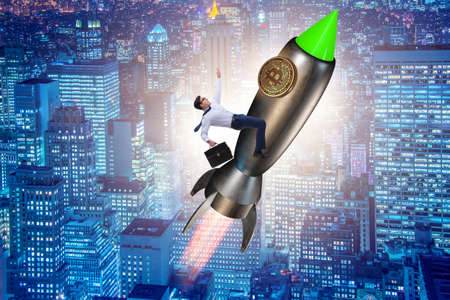 Businessman flying on rocket in bitcoin price rising conceptの写真素材