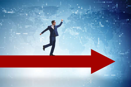 Businessman walking on arrow in business conceptの写真素材
