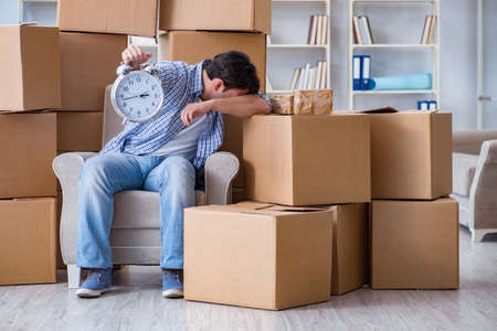 Young man moving in to new house with boxesの写真素材