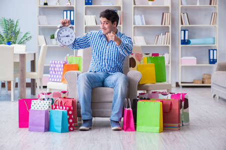 Young man after excessive shopping at homeの写真素材