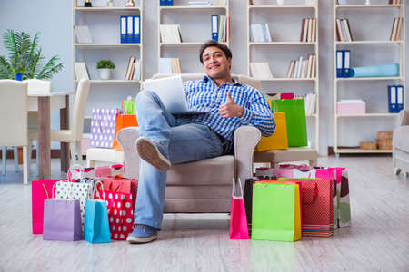 Young man after excessive shopping at homeの写真素材