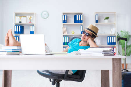 Businessman preparing for vacation in the officeの写真素材