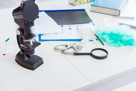 Criminologist police chemist looking at crime evidenceの写真素材