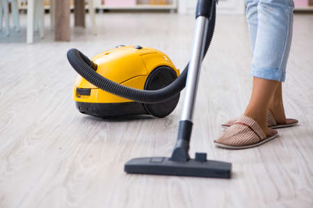 Woman doing cleaning at home with vacuum cleanerの写真素材