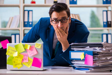 Businessman with reminder notes in multitasking conceptの写真素材