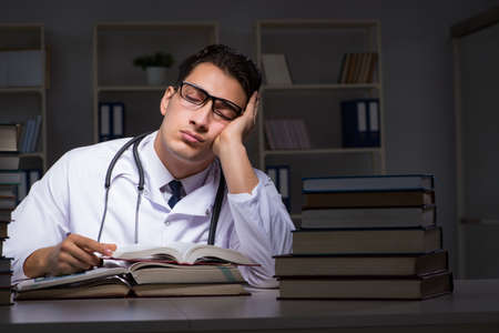 Medical student preparing for university exams at nightの写真素材