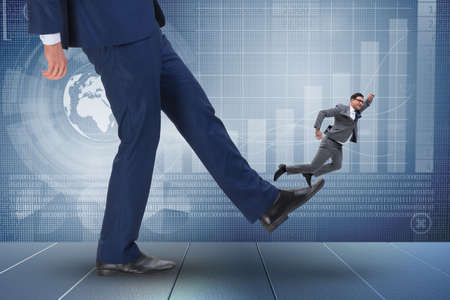 Bad angry boss kicking employee in business conceptの写真素材