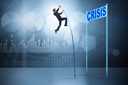 Businessman pole vaulting over crisis in business concept