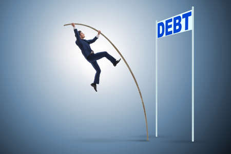Businessman pole vaulting over debt in business conceptの写真素材