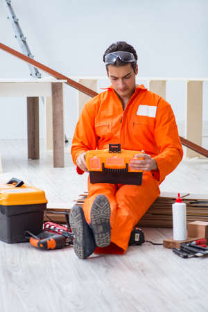 Contractor working on laminate wooden floor