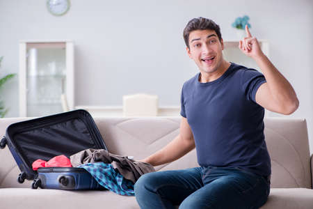 Young man preparing packing for summer vacationの写真素材