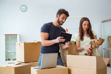 Young family unpacking at new house with boxes