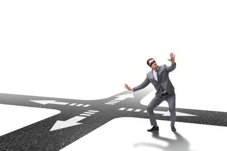 Young businessman at crossroads in uncertainty conceptの写真素材