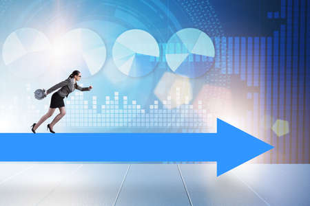 Businesswoman walking on arrow signの写真素材