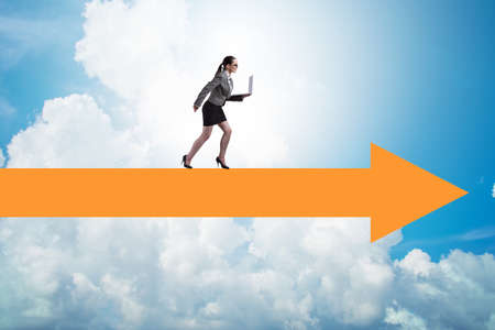 Businesswoman walking on arrow signの写真素材