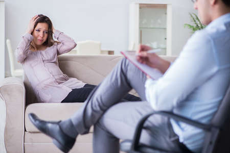 Pregnant woman visiting psychologist doctorの写真素材