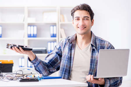 Professional repairman repairing computer in workshop