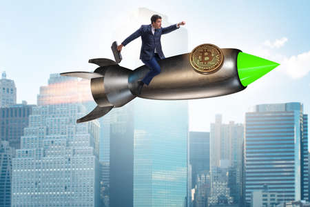Businessman flying on rocket in bitcoin price rising conceptの写真素材