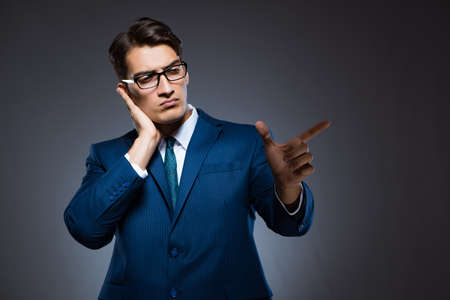 Businessman pressing virtual buttons on gray backgroundの写真素材
