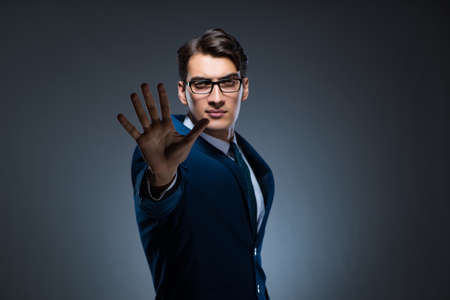 Businessman pressing virtual buttons on gray backgroundの写真素材