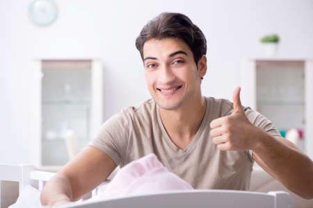 Young father enjoying time with newborn baby at homeの写真素材