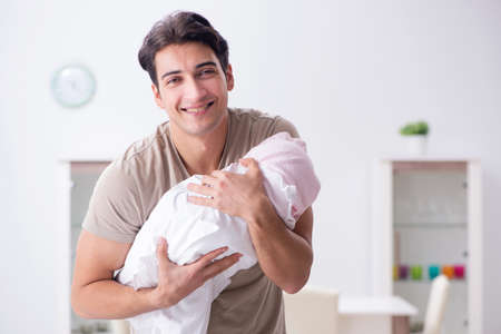 Young father enjoying time with newborn baby at homeの写真素材