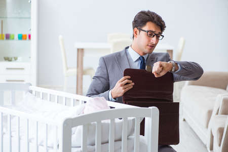 Young businessman trying to work from home caring after newborn babyの写真素材