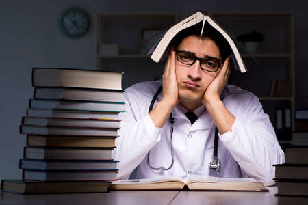 Medical student preparing for university exams at nightの写真素材
