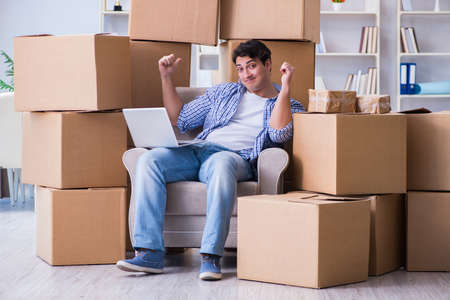 Young man moving in to new house with boxes