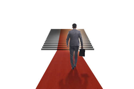Young businessman climbing stairs and red carpet on white backgroundの写真素材