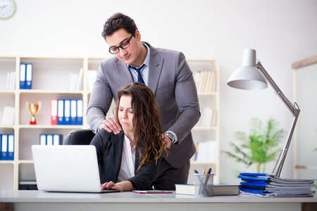 Sexual harassment concept with man and woman in officeの写真素材